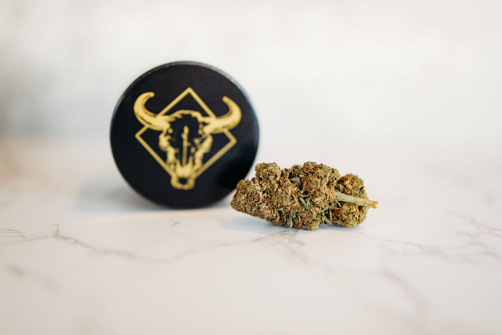cannabis flower and a logo on a white surface